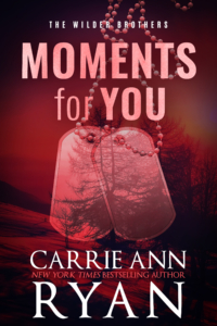 Red cover of Moments for you. Dogtags in the foreground. Trees in the background.